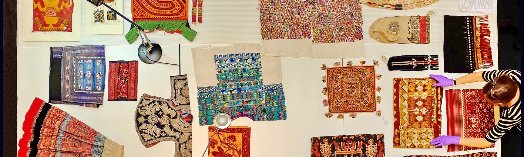View from above of colourful textiles being laid out on table
