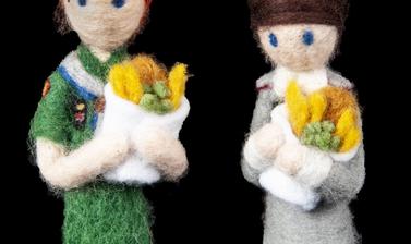Two felted figures dressed in midwife uniforms and holding felted fish and chips.