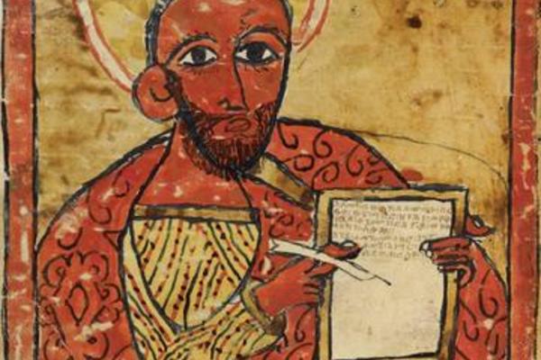 Detail from illustrated manuscript showing the Evangelist Luke holding a page and a pen