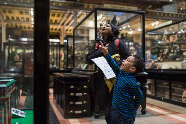 A family looking into a display case at the Pitt Rivers Museum