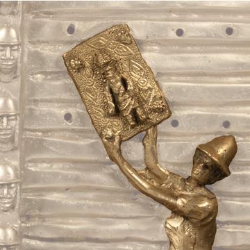Bronze figurine depicting a British soldier wearing a pith helmet removing a bronze plaque from a wall